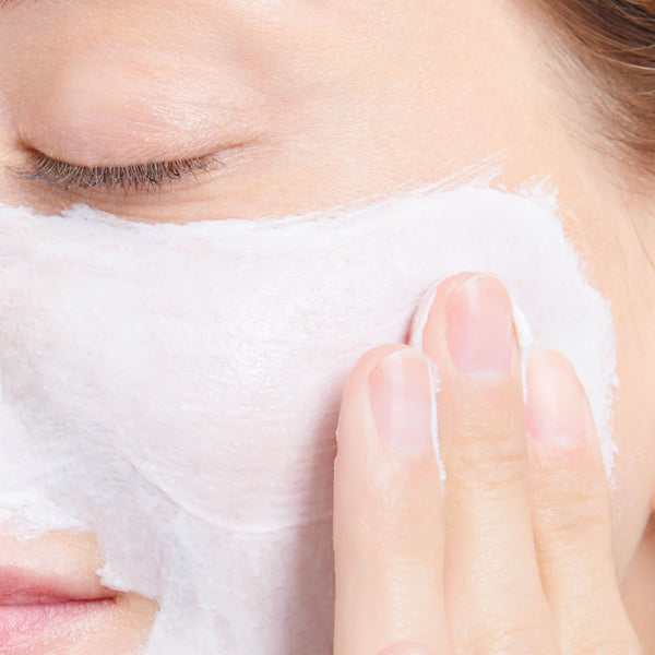 woman massaging cream into her skin
