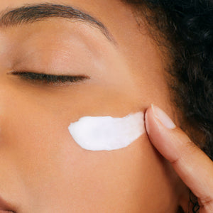 Close-up of a person applying ultra vital cream to their face