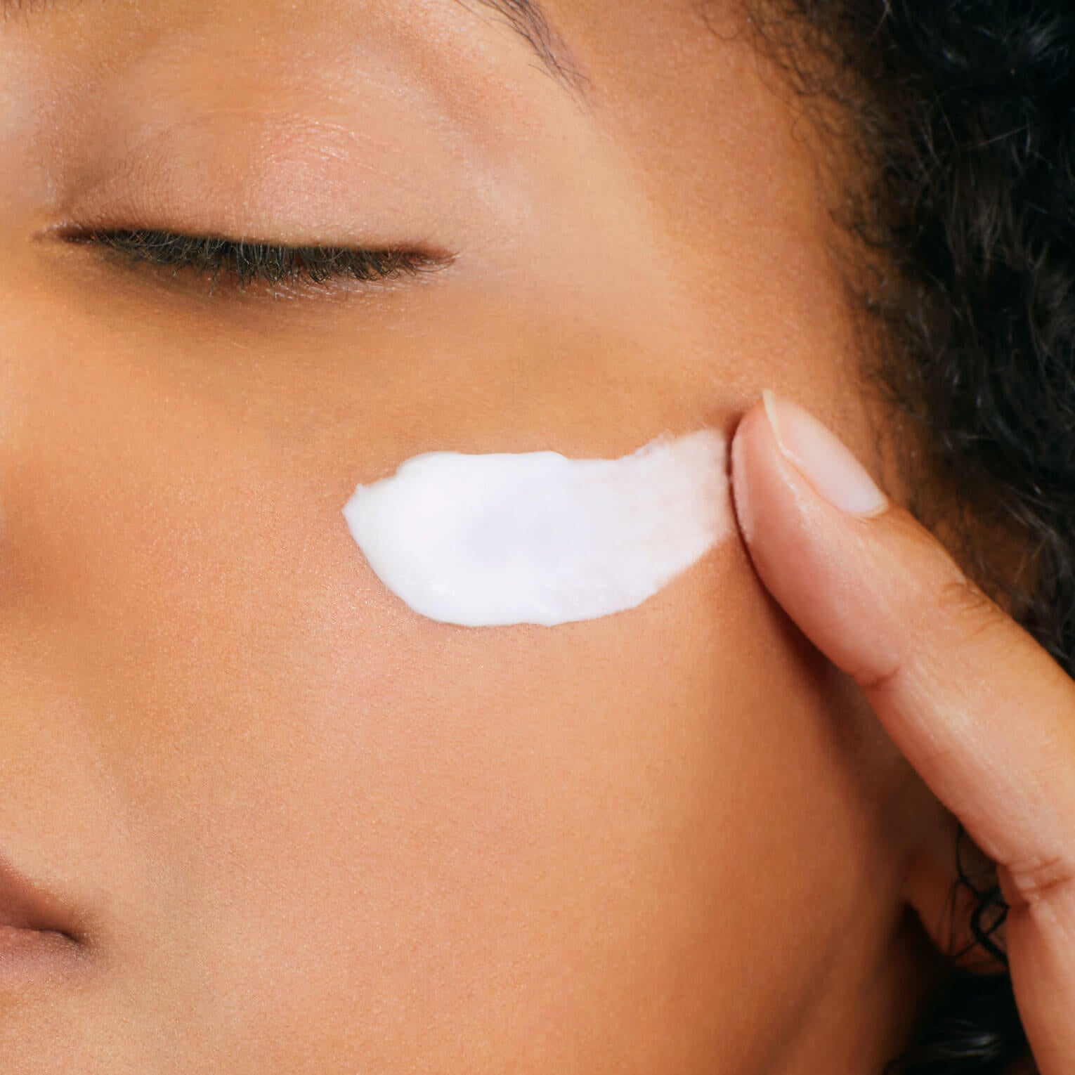 Close-up of a woman applying anti stress mask to their face