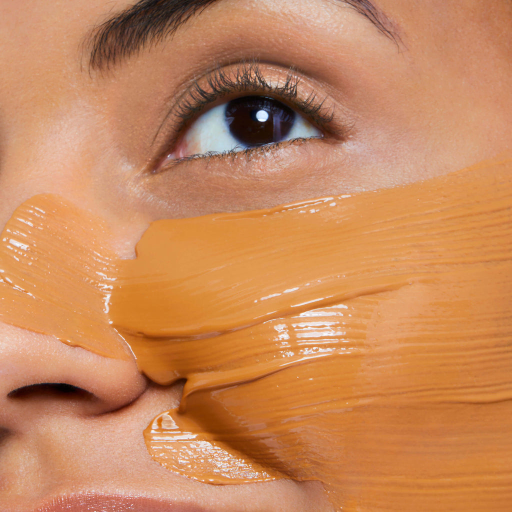 Close-up of a person's eye with brown precious mask applied to the face