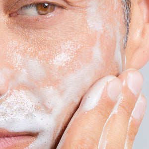 Close-up of a person applying cellmen wash n shave foam to their face