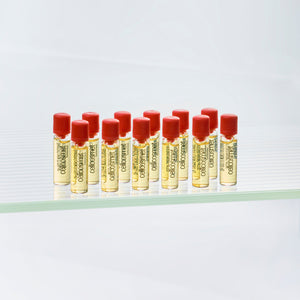 Row of small elasto ultra intensive bottles with red caps on a white background
