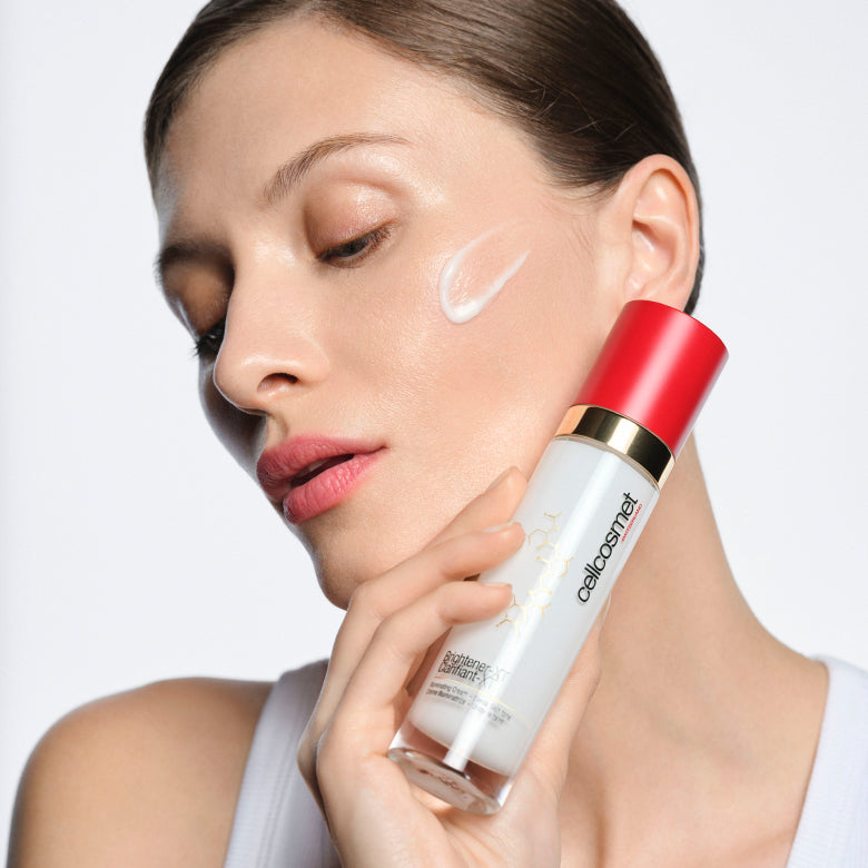 Model holding Cellcosmet Birghtener-XT with product on her face
