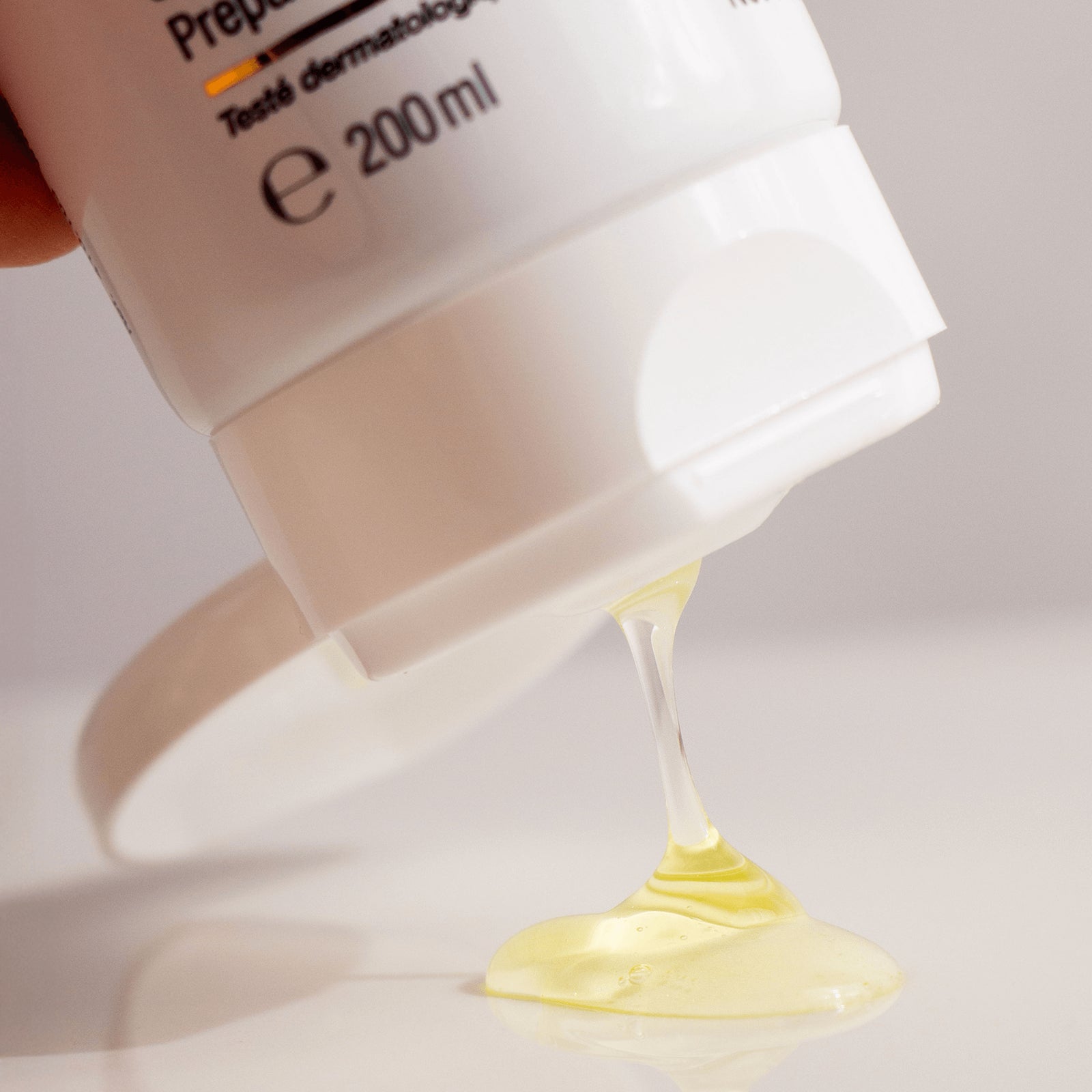 Close-up of a skincare product activator gel with a small amount of cream being squeezed out onto a white surface.