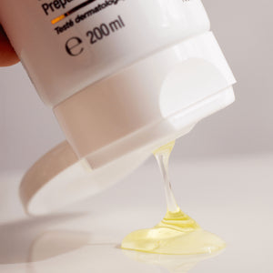 Close-up of a skincare product activator gel with a small amount of cream being squeezed out onto a white surface.