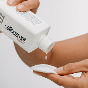 Person applying active tonic from a Cellcosmet bottle onto a cotton swab.