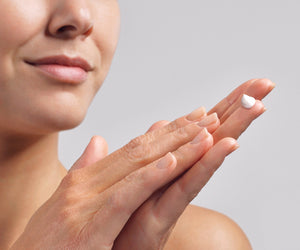 Model has a drop of CellLift Cream Light in her hands and is about to apply it.