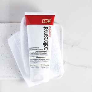 Cellcosmet Gentle Purifying Cleanser 200ml with towel behind it and soap dish on a bathroom countertop.
