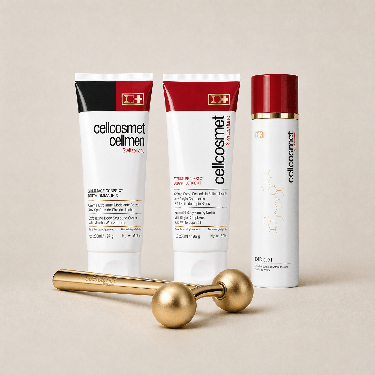 Three Cellocosmet skincare products and a gold facial roller are arranged on a warm beige background. The products include a body cream tube, a body butter tube, and a serum bottle, all in white packaging with red and black accents, alongside a polished gold metal facial roller.