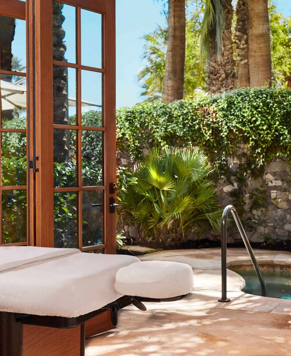 Spa treatment room with a view of a pool and garden